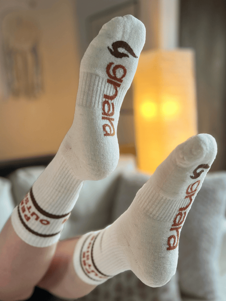 Image of the bottom side of "Pee Outside" socks displaying Gnara logo