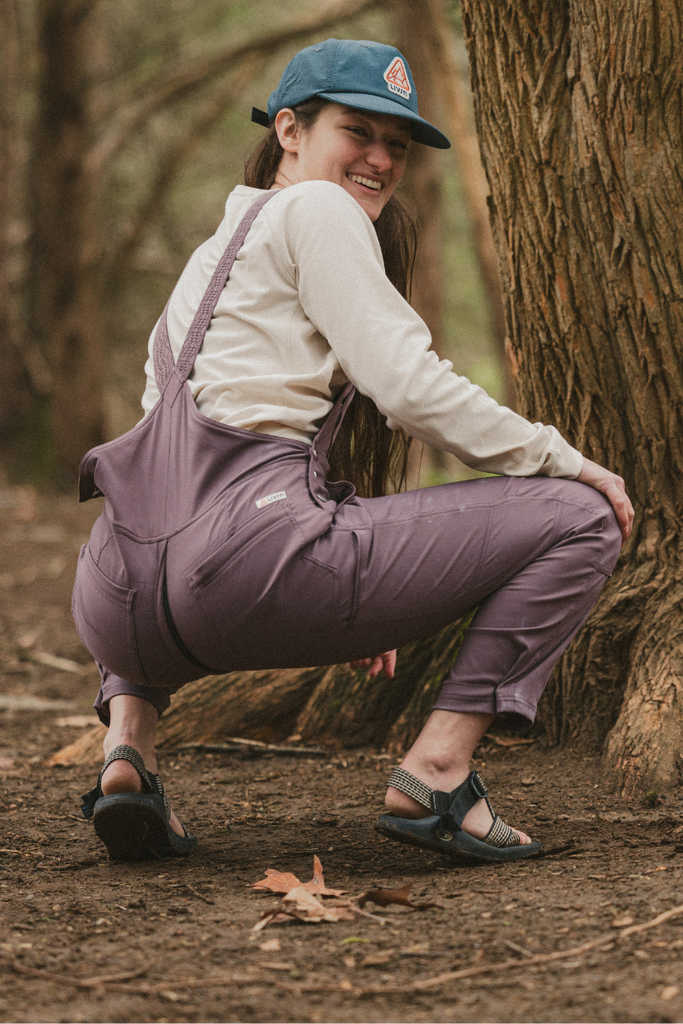 Model squatting in the Ecotrek overalls in Plum