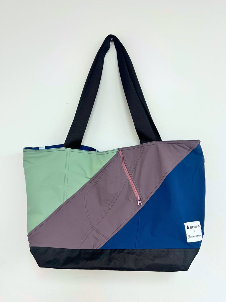 Color-blocked tote bag with a visible brand label on a white background