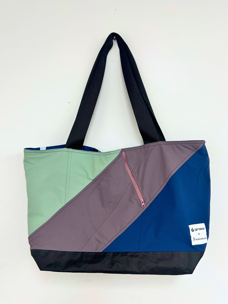 Color-blocked tote bag with jade, granite, and blue sections on a white background