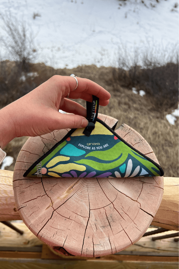 Kula with wild flora design folded on a wooden stump